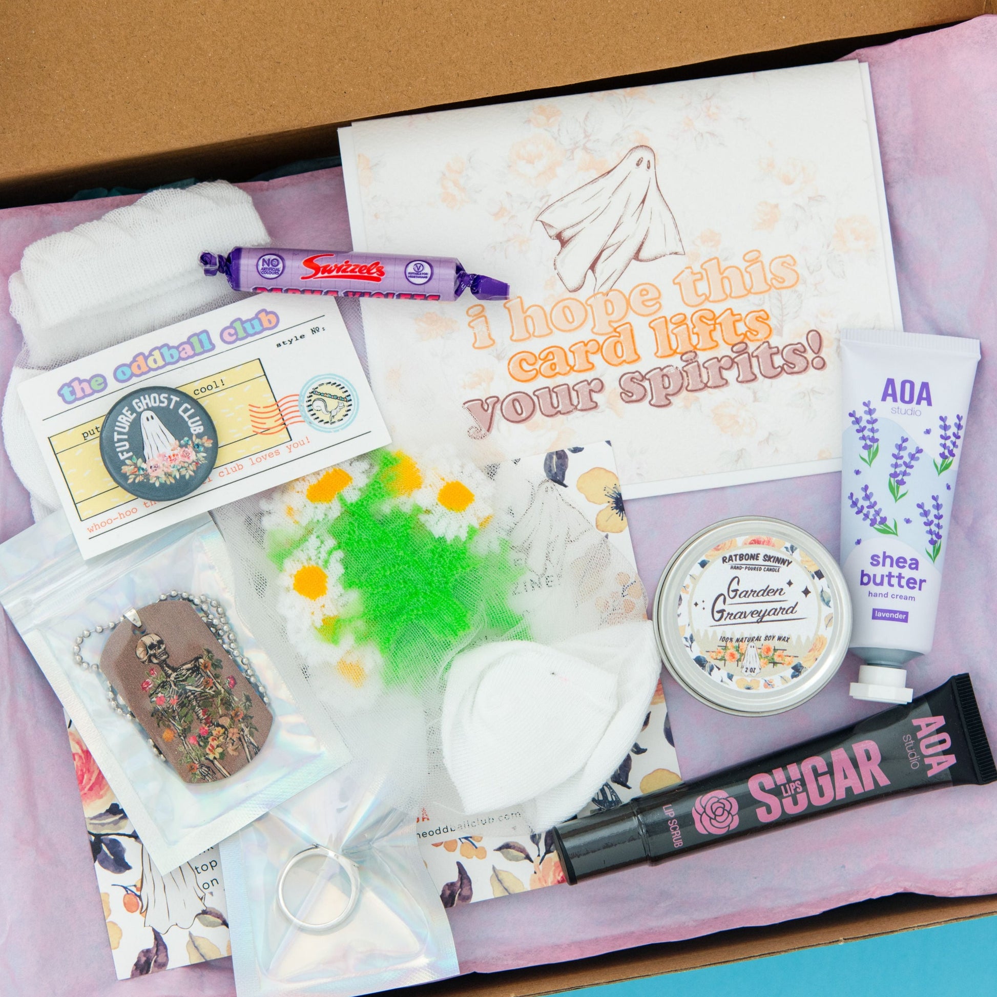 Ghost Greeting Card subscription box featuring a beautiful floral background. Includes a mini candle with a spooky scent, sheer daisy flower socks, luxurious hand lotion, and a spooky ghost greeting card. Perfectly blending elegance and eeriness. Order now to get into the spooky spirit!