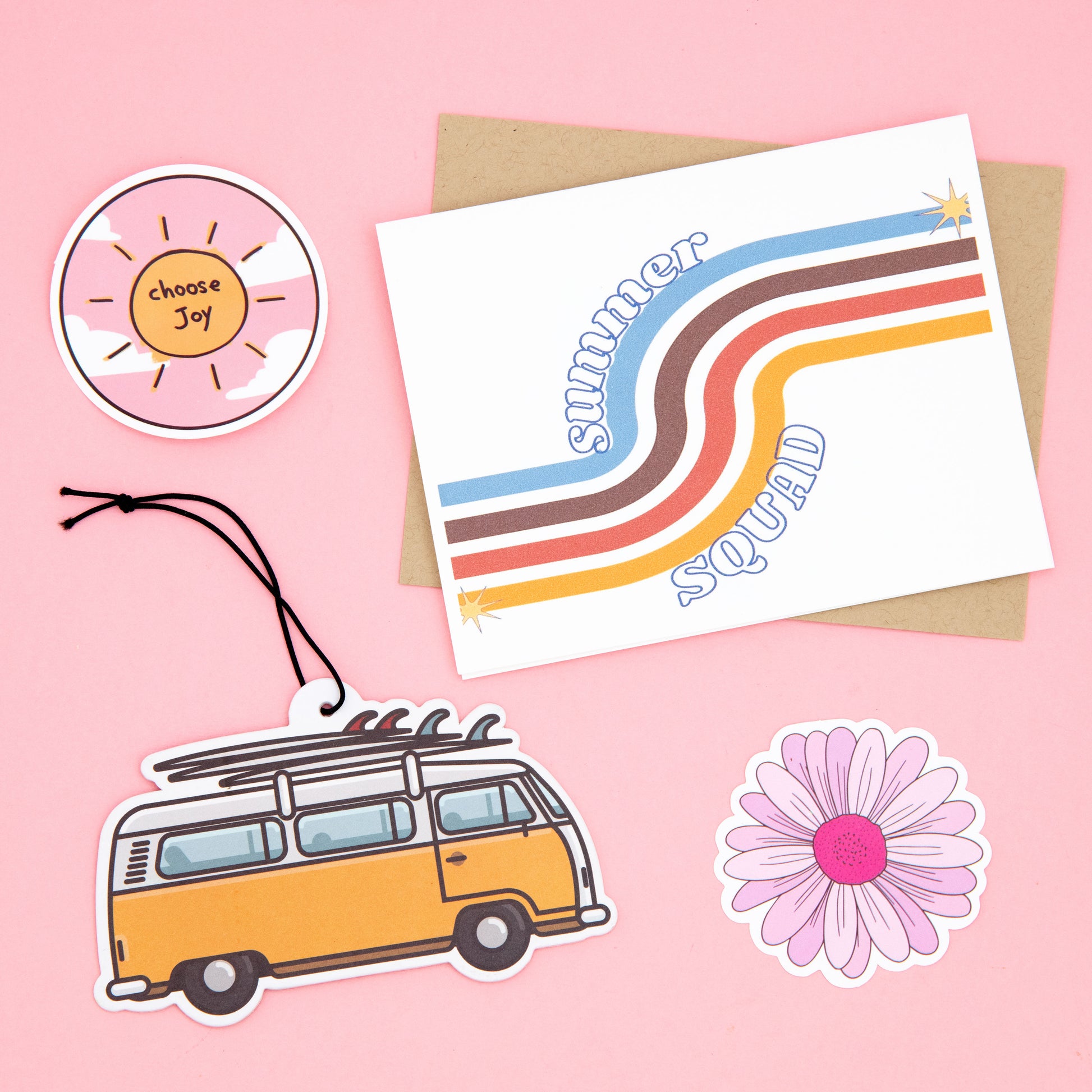 Get ready for summer with The Oddball Club's subscription box! This box includes a summer squad greeting card with a retro line pattern, brown envelope, flower sticker, sun sticker that says 'choose joy', and a vintage yellow van air freshener with surf boards. Perfect for beach lovers and summer enthusiasts.