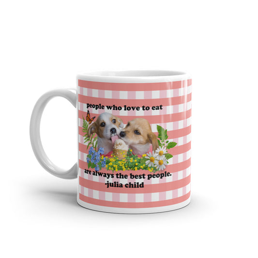 A mug with red plaid and a quote from Julia Child "people who love to eat are always the best people" with two doggies licking up an ice cream treat sourrounded by flowers, leaves, ferns, and an orange butterfly